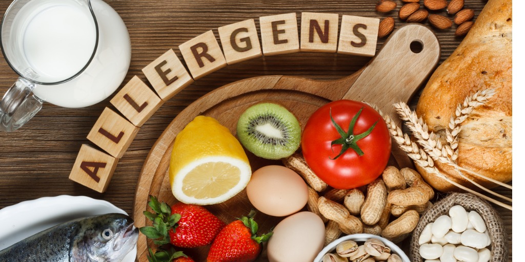 plate of food with scrabble pieces spelling allergens - article discusses new treatments for food allergies and anaphylaxis