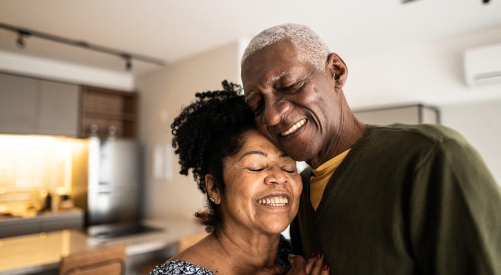 Senior couple embracing each other at home